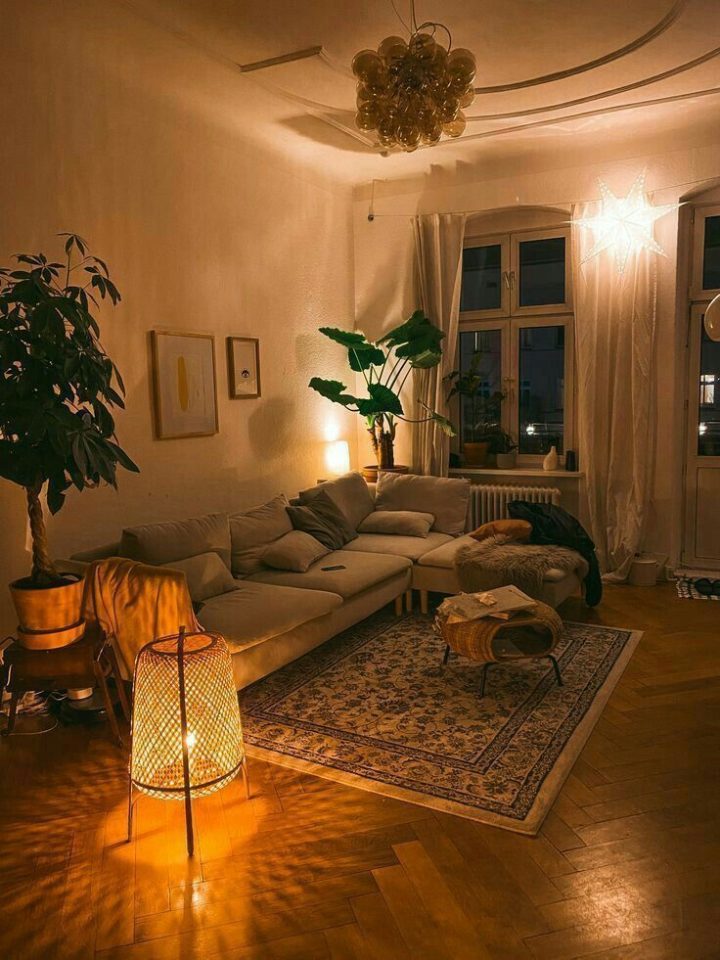 Phòng khách ấm cúng với sofa xanh rêu và đèn vàng
